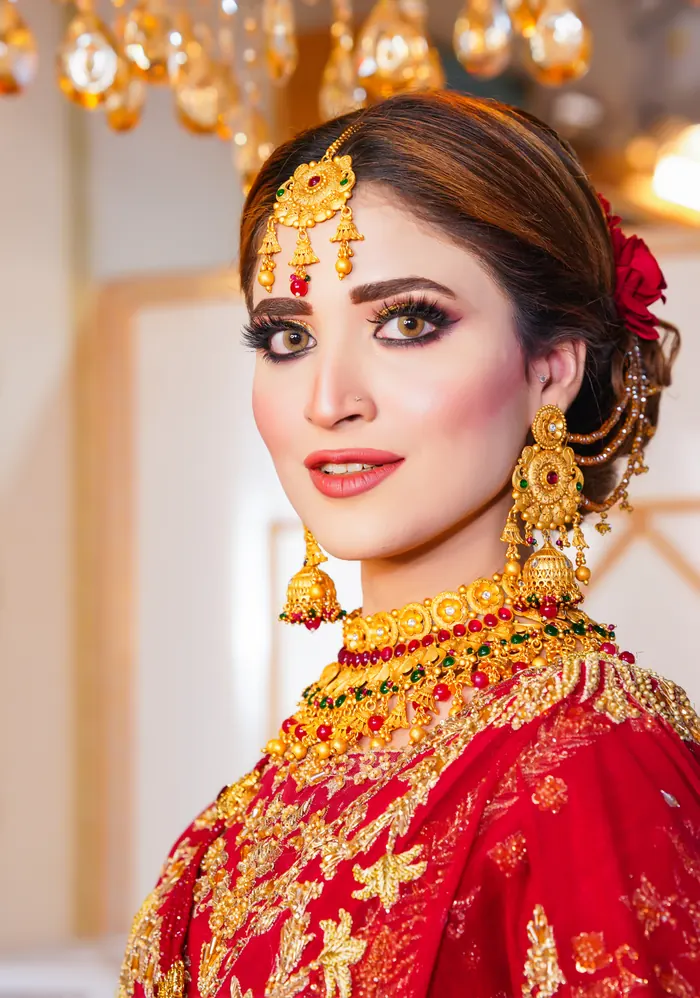 Bride in red with gold jewellery and a soft glam finish