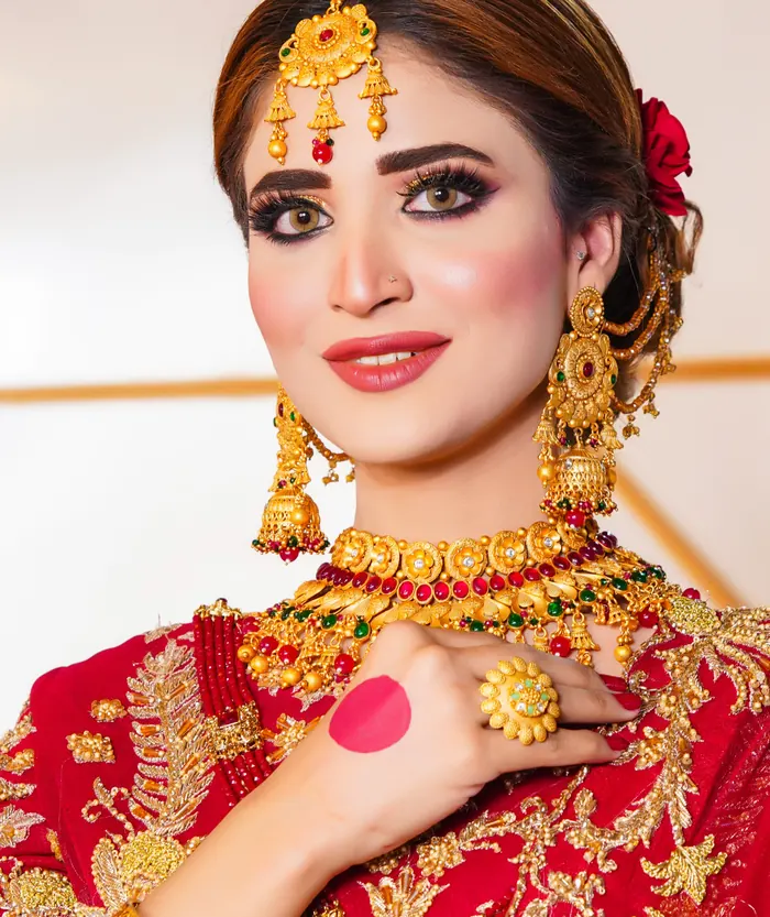 Bride in red holding her dupatta, nath and bangles